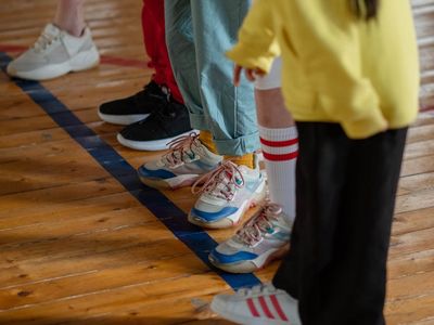 Detail of sports shoes on a gym floor.
